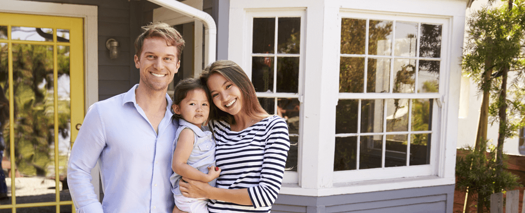 happy family in front of their new home